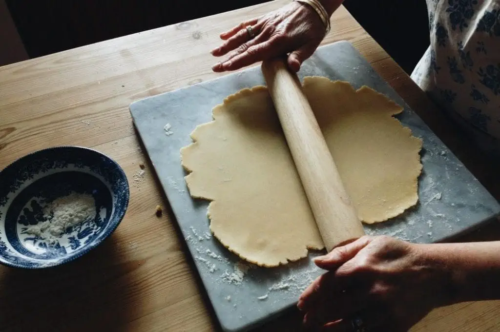 A woman rolling out the dough